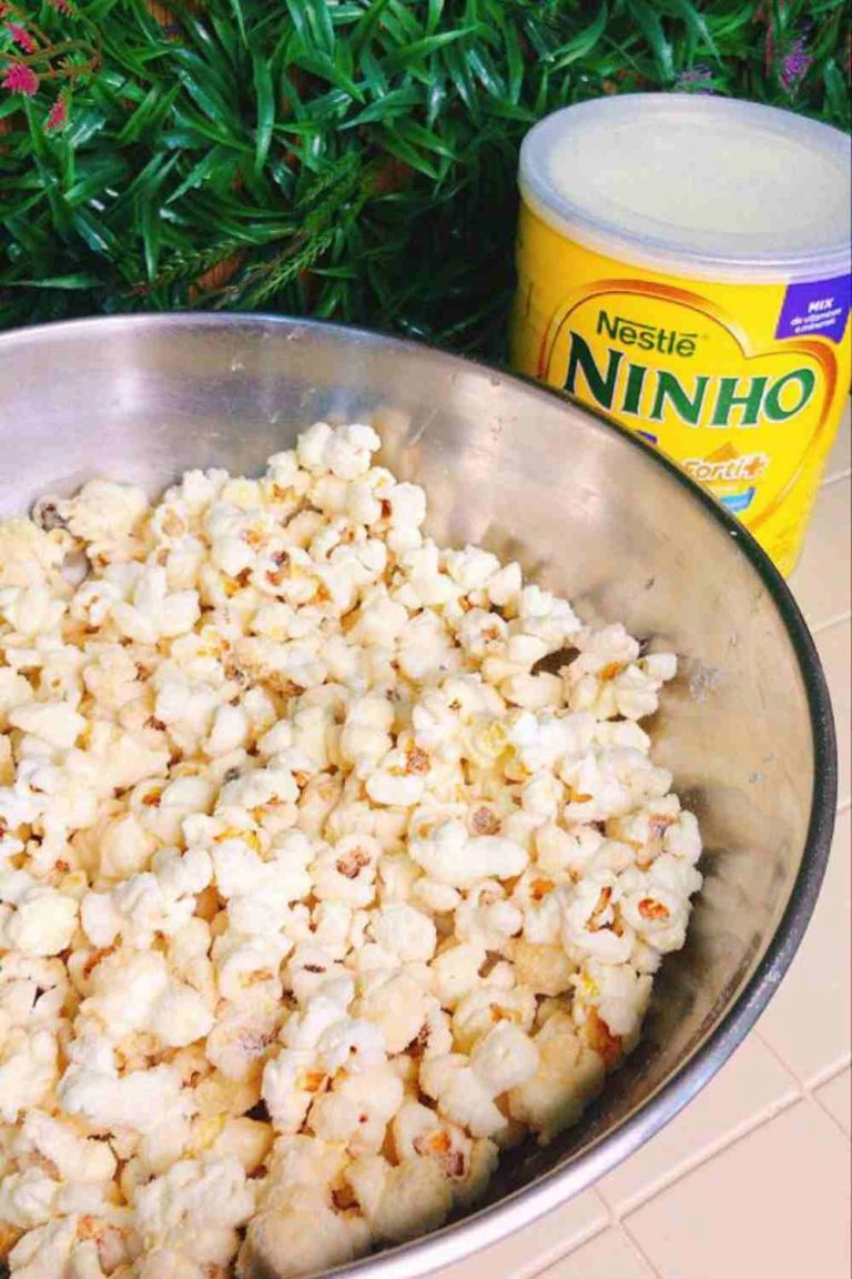 Pipoca Gourmet de Leite Ninho já pronta, em uma bacia de metal com uma lata de leite em pó ao lado